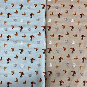 May include: Two fabric swatches with a repeating pattern of brown chickens on a light blue background and a tan background.