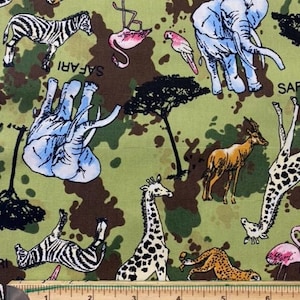 May include: Green fabric with a camouflage pattern featuring various safari animals, including zebras, giraffes, elephants, and flamingos. The fabric also includes the word "SAFARI" printed on it.