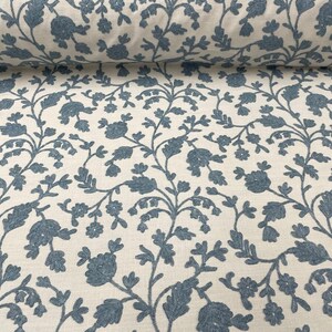 May include: White fabric with a blue floral pattern. The pattern features small blue flowers and leaves on a white background.