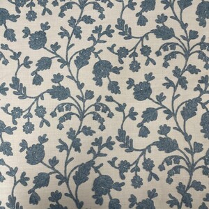 May include: A white fabric with a blue floral pattern. The pattern features small flowers and leaves in a repeating design.