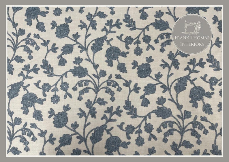 May include: A white fabric with a blue floral pattern. The pattern features small flowers and leaves, creating a delicate and intricate design. The fabric is perfect for upholstery, curtains, or other home decor projects.