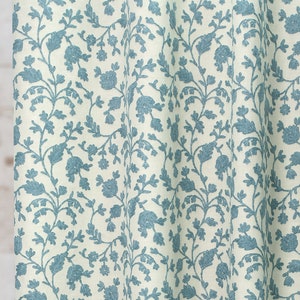 May include: A white fabric with a blue floral pattern. The pattern features small flowers and leaves.