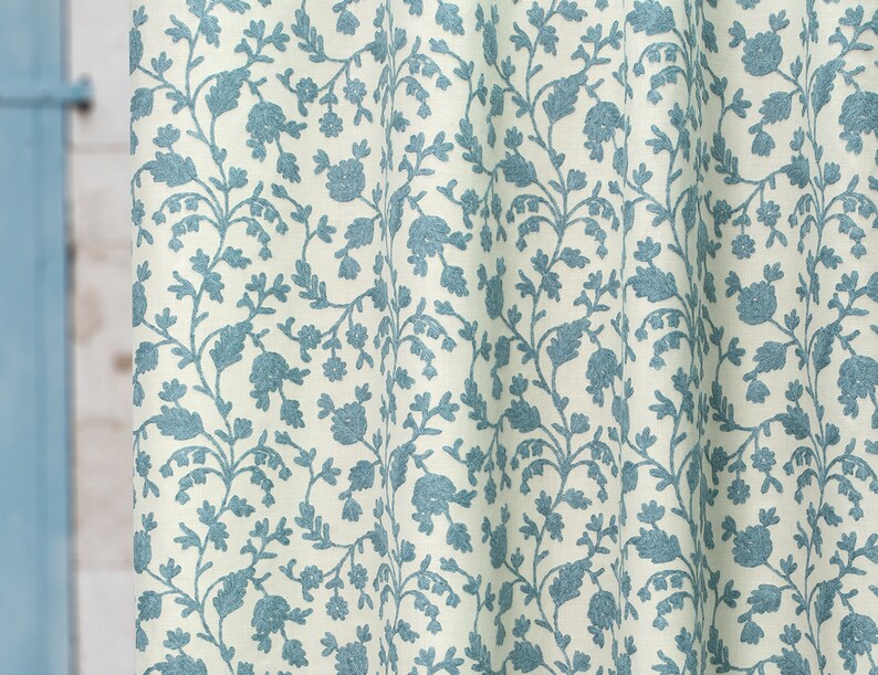 May include: A white fabric with a blue floral pattern. The pattern features small flowers and leaves.
