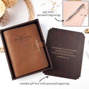 K&ouml;nnte beinhalten: Ein braunes Leder-Rezeptbuch mit den Namen "Megan & Robert Williams" und "Family Recipes" auf dem Einband, pr&auml;sentiert in einer Holzgeschenkbox. Enth&auml;lt einen Stift und einen Holzeinsatz mit einem Bibelvers.
