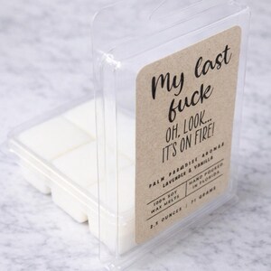 a clear plastic container with a printed label, containing white cubes of what appears to be a scented wax or candle.