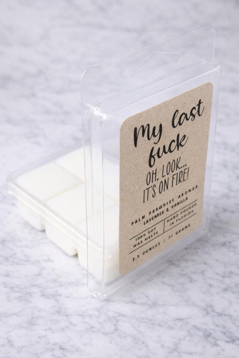 a clear plastic container with a printed label, containing white cubes of what appears to be a scented wax or candle.
