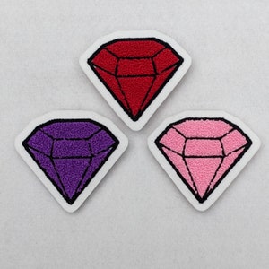 May include: Three embroidered iron-on patches shaped like diamonds. The diamonds are red, purple, and pink.