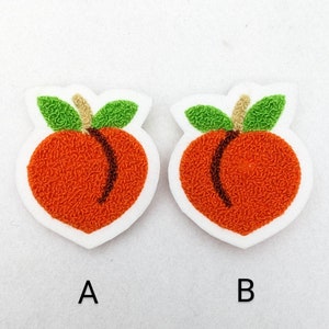 Può includere: Due applicazioni in feltro a forma di pesca con foglie verdi e steli marroni. Le pesche sono arancioni e hanno una superficie testurizzata. Le applicazioni sono etichettate con A e B.