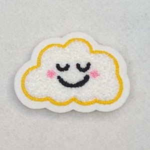 Peut inclure: Un nuage blanc avec un contour jaune et un visage souriant avec les yeux fermés. Le nuage a des joues roses.