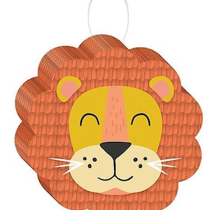 May include: Orange and yellow lion face pinata with a smiling expression. The pinata has a loop at the top for hanging.