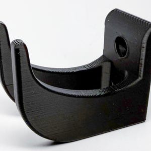 Puede incluir: Gancho de pared de pl&aacute;stico negro con dos puntas. El gancho est&aacute; dise&ntilde;ado para sujetar una variedad de art&iacute;culos, como abrigos, sombreros o bolsos.