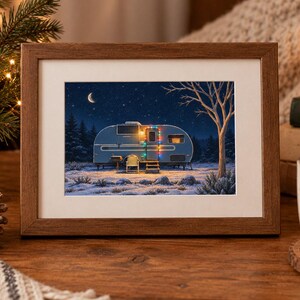 May include: A rectangular wooden frame containing a print of a blue vintage camper parked in a snowy landscape at night. The camper is decorated with colorful string lights, and the scene features a crescent moon, stars, and a bare tree.