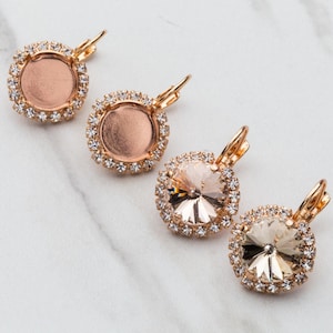 May include: Four gold-tone earrings with clear crystal accents. Two earrings feature a round, clear crystal with a faceted design. The other two earrings feature a round, clear, bezel-set setting.