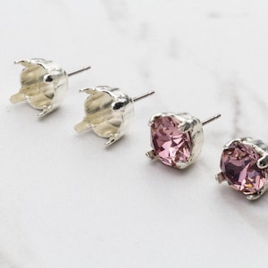 May include: Three silver earring settings with a pink rhinestone in each setting. The settings are round and have a prong setting for the rhinestone.