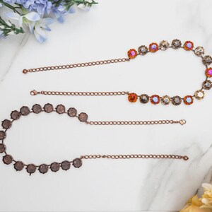 May include: Two necklaces with copper-colored chains and decorative elements. One necklace features a series of iridescent, round gemstones. The other necklace has a series of round, dark brown, textured elements. Both necklaces are displayed on a white marble surface.