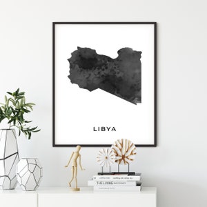 May include: Black and white watercolor print of the outline of Libya with the word "LIBYA" printed below the map.