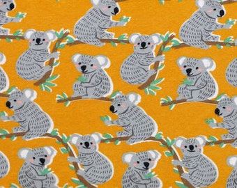 May include: A yellow fabric with a repeating pattern of gray koala bears on branches. The koalas are in various poses, some sitting, some standing, and some climbing. The branches are brown and have green leaves.