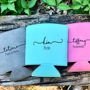 May include: Three personalized can coolers, one gray with the text "tatiana Maid of Honor", one turquoise with the text "kim Bride", and one pink with the text "tiffany Bridesmaid".