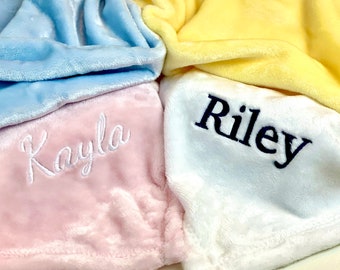 May include: Three personalized plush blankets in pink, white, and blue with the names "Kayla" and "Riley" embroidered on them.
