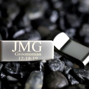 May include: Silver money clip with the initials JMG, the word "Groomsman" and the date "12-18-19" engraved on it.