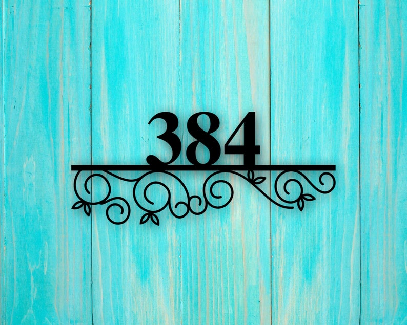 May include: Black metal house number sign with the number 384 on a turquoise wooden background. The number is attached to a decorative scrollwork design.