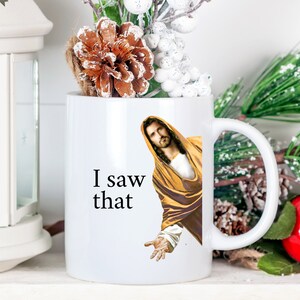K&ouml;nnte beinhalten: Wei&szlig;e Keramik-Kaffeetasse mit einem Schwarzwei&szlig;bild von Jesus und dem Text "I saw that".