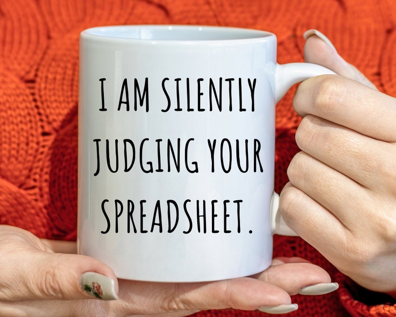 May include: White ceramic mug with black text that reads "I am silently judging your spreadsheet."