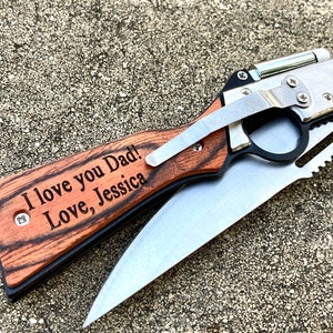 Puede incluir: Un cuchillo de bolsillo con mango de madera, una hoja de plata y una sierra. El mango est&aacute; grabado con las palabras "I love you Dad! Love, Jessica".