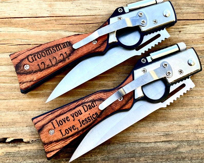 May include: Two personalized pocket knives with wooden handles. The top knife has the text "Groomman 12-12-21" engraved on the handle. The bottom knife has the text "I love you Dad! Love, Jessica" engraved on the handle.