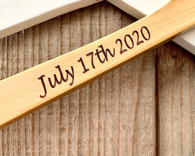 May include: Close-up of a wooden sign with the date "July 17th 2020" engraved on it.