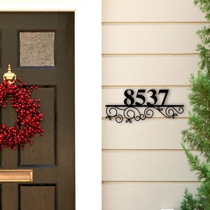 May include: Black metal house number sign with a decorative scroll design. The number 8537 is displayed on the sign.
