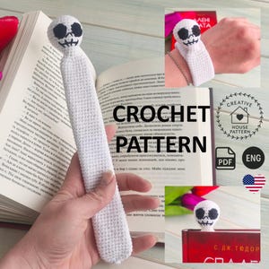 Puede incluir: Un marcapáginas de ganchillo blanco con una cabeza de calavera con ojos y boca bordados en negro. El cuerpo largo, plano y rectangular está hecho de puntos de hilo blanco denso. El artículo se muestra como un patrón PDF digital.