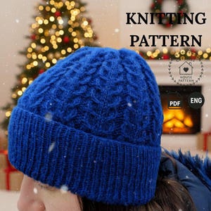 May include: A vibrant blue knitted beanie featuring a textured cable knit pattern on the crown and a ribbed cuff. The image includes the text KNITTING PATTERN, a circular logo with a house icon, and labels indicating PDF and ENG format.