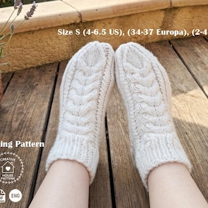 Può includere: Un paio di calzini lavorati a maglia a mano color bianco sporco con un motivo a trecce verticali e polsini a coste. L'immagine include il testo Size S (4-6.5 US), (34-37 Europa), (2-4.5 UK), Knitting Pattern, Creative House Pattern e PDF ENG.