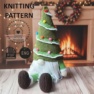 Könnte beinhalten: Ein gestrickter Weihnachtsbaum-Wichtel mit einem grünen, baumförmigen Hut, der mit bunten Pompons und weißem Besatz verziert ist. Der Wichtel hat einen langen weißen Bart, braune Füße und grüne Arme. Das Bild enthält den Text "KNITTING PATTERN" und "CREATIVE HOUSE PATTERN".