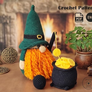 May include: A handmade crochet gnome with a green hat, orange beard, and a black pot filled with yellow coins. The gnome holds a black staff with a yellow ball. The image also includes a small black ball and a plant in a brown pot.