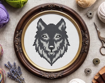 Peut inclure: Une broderie au point de croix représentant une tête de loup dans des tons de gris et de noir sur un tissu blanc, encadrée dans un cadre rond en bois brun foncé orné avec un bord intérieur doré, montrant un motif géométrique détaillé.