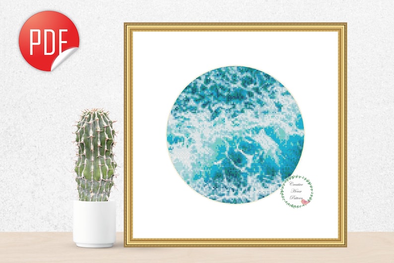 May include: A digital cross stitch pattern featuring a circular design of blue and white ocean waves. The pattern is framed in a gold frame and displayed on a white wall.