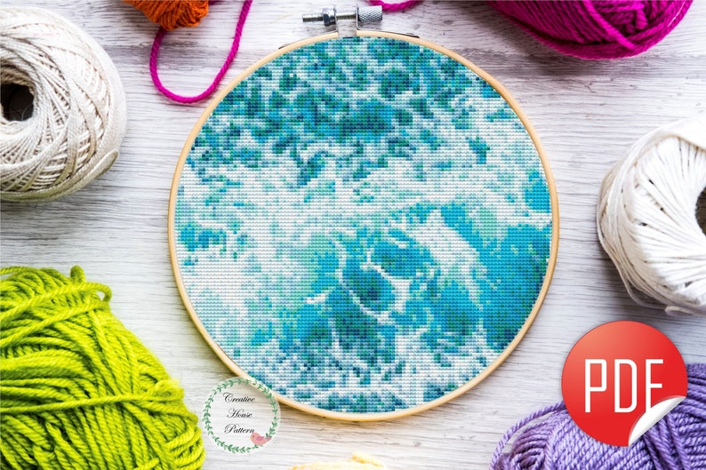A framed cross-stitch pattern of a blue and white ocean wave design.
This ocean cross stitch pattern makes a perfect handmade gift for mom, grandmother, sister, best friend, coworker, ocean lover, beach lover, surfer, marine biologist, sailor, nature lover, cross stitcher, crafty mom, embroidery enthusiast, new homeowners, beach house decor, coastal living room wall art, bathroom decor, housewarming gift, summer birthday gift.