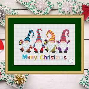 Puede incluir: Patrón de punto de cruz con cuatro gnomos coloridos con barbas blancas y el texto "Feliz Navidad".