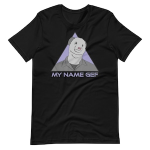 May include: Black t-shirt featuring a purple triangle with a cartoon ferret wearing a blue shirt. The text "MY NAME GEF" is printed below the triangle.