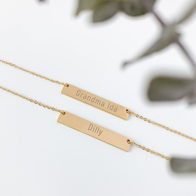 May include: Two gold bar necklaces with the names "Grandma Ida" and "Dilly" engraved on them.