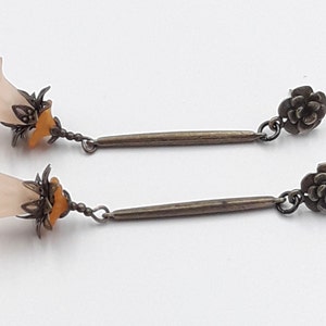 Hanging earrings with bronze metal rod and peach colored flower