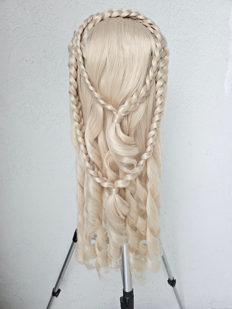 May include: A blonde wig with long, curly hair styled in a braided crown and loose curls cascading down the back.