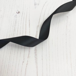 Band: Satin, Doppelseitig in Schwarz. 15 mm breit bei 1 Meter Länge
