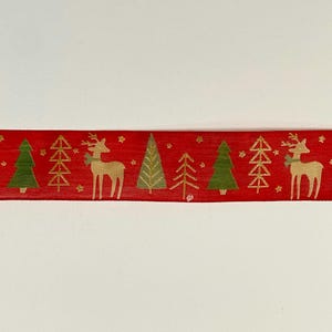 Può includere: Nastro rosso con un motivo ripetuto in oro e verde di alberi di Natale e renne stilizzati.