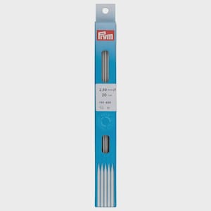 May include: A package of Prym knitting needles. The blue and white package displays the Prym logo and product information, including the needle size of 2.50 mm and a length of 20 cm (7.87 inches). The package contains several silver knitting needles.