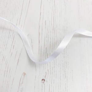 リボン: 白色の薄いサテンの両面リボン。幅 6 mm、長さ 1 メートル