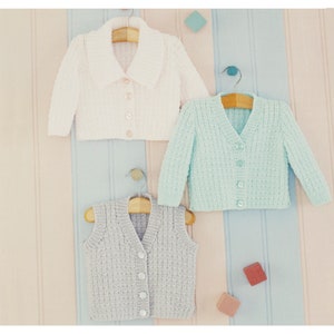 May include: Three knitted baby garments: a white cardigan with a collar, a light blue cardigan, and a gray vest. All garments have button closures.