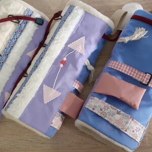 Puede incluir: Tres rollos de actividad de tela para bebés y niños pequeños. Los rollos están hechos de diferentes telas y tienen varias texturas, colores y patrones. Los rollos están diseñados para estimular los sentidos del niño y fomentar la exploración.